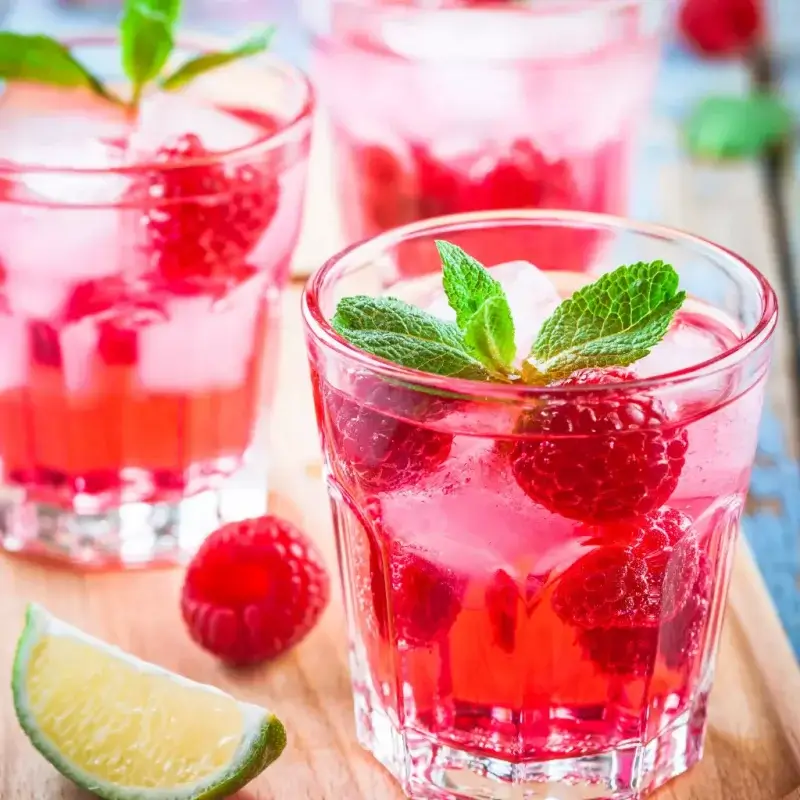 alcoholvrije mocktail met frambozen en limoen in glas met frambozen en munt